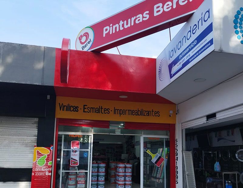 Un edificio rojo y amarillo con autos estacionados frente a él.