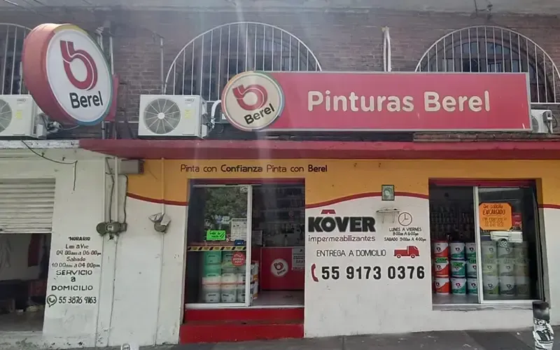 El frente de una tienda con un cartel rojo que dice pintura berel.