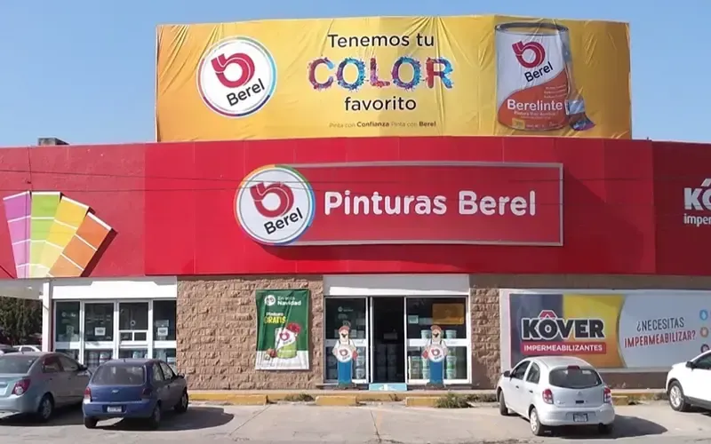 Un edificio rojo y amarillo con autos estacionados frente a él.