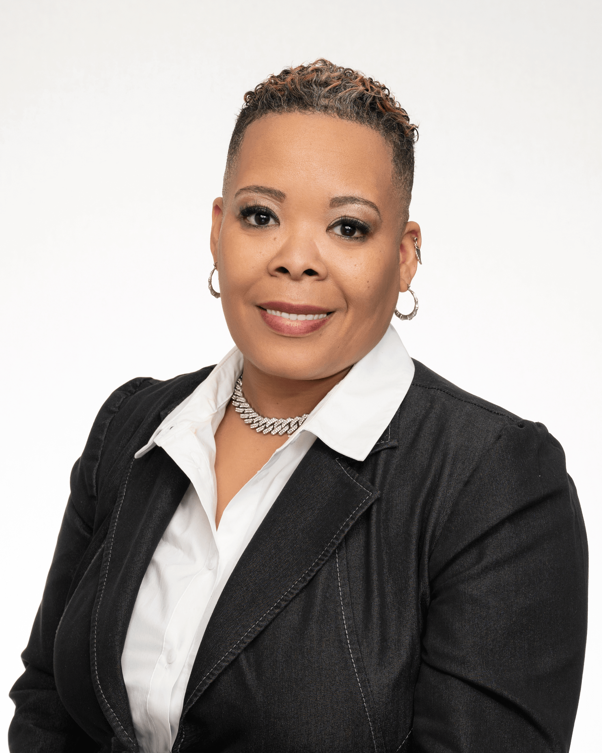 a woman in a black jacket and white shirt is smiling for the camera .