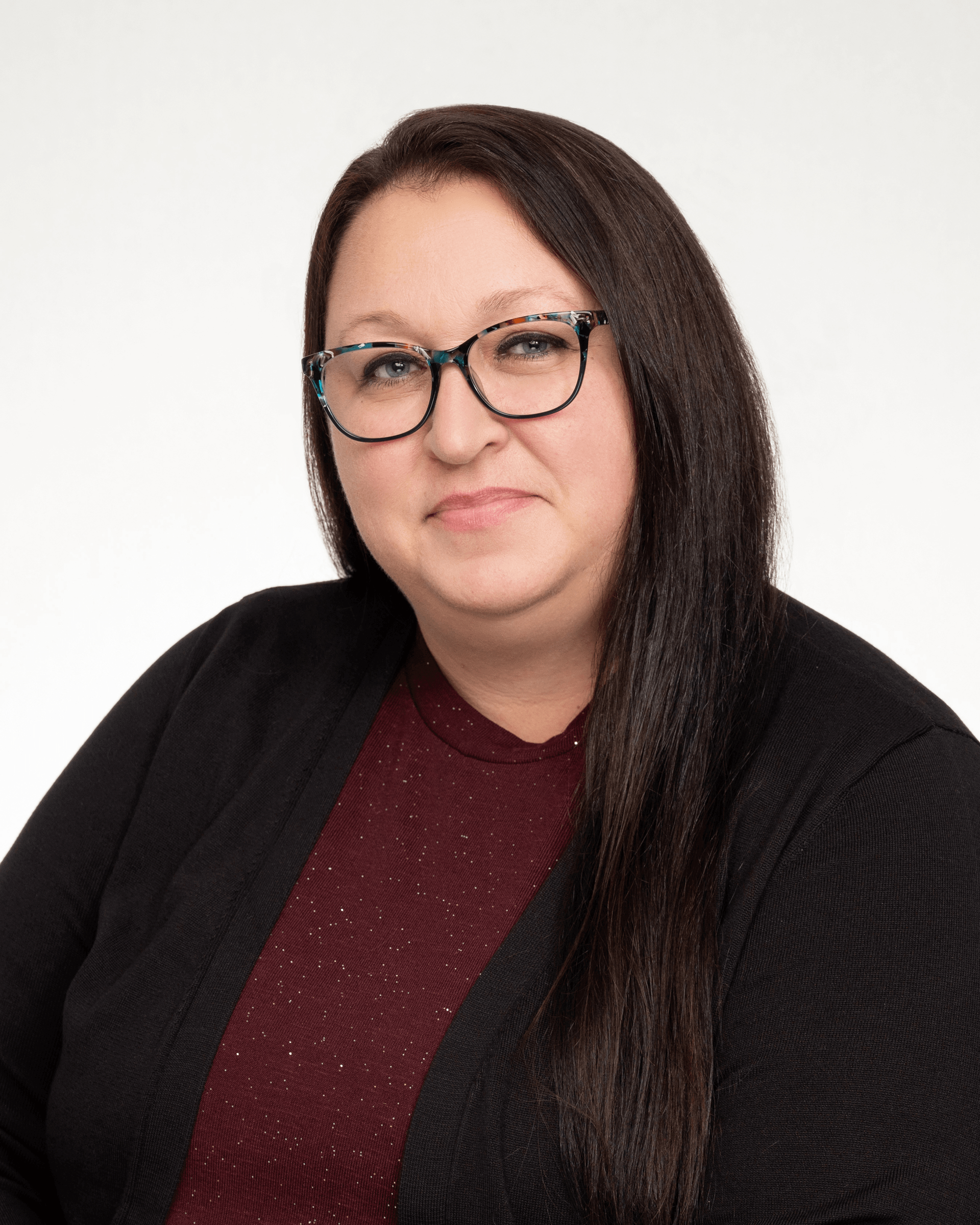 a woman wearing glasses and a black sweater is smiling for the camera .