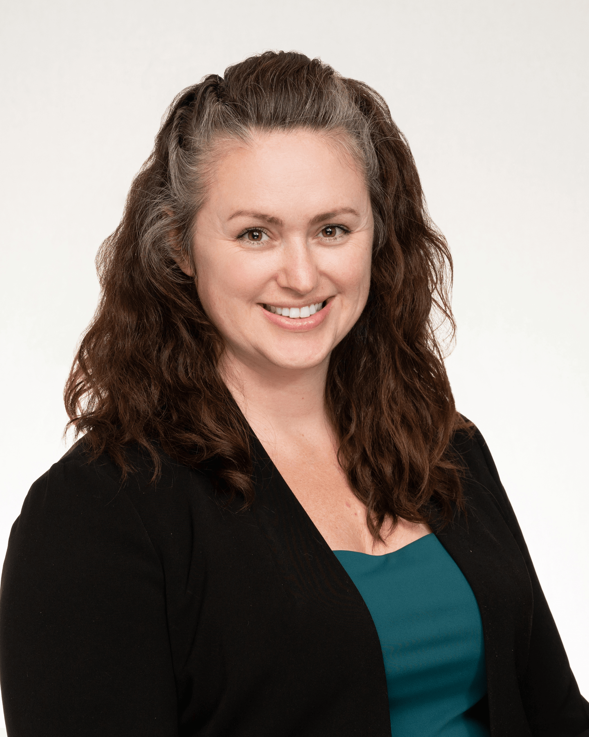 a woman wearing a black sweater and a blue shirt is smiling for the camera .