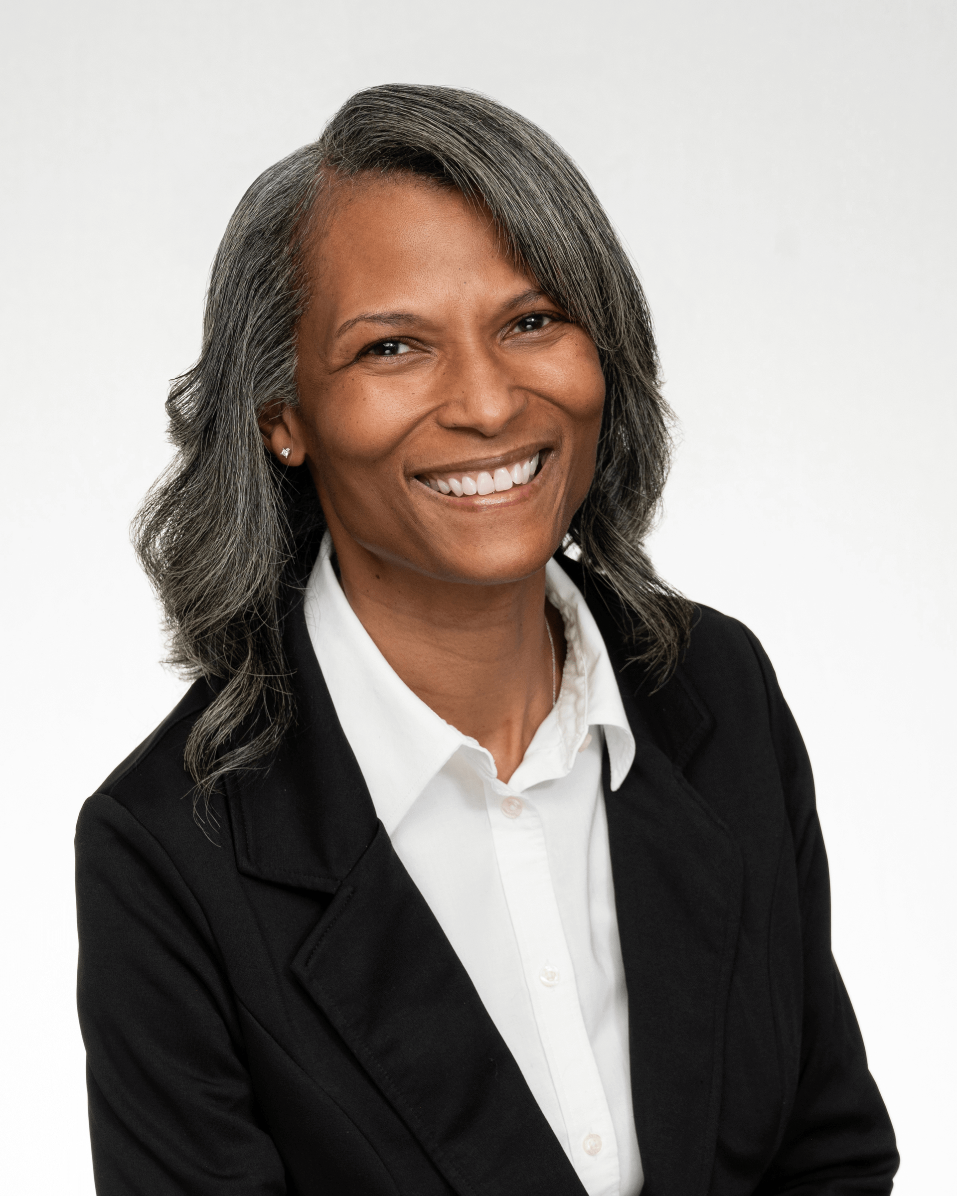 a woman in a black jacket and white shirt is smiling for the camera .