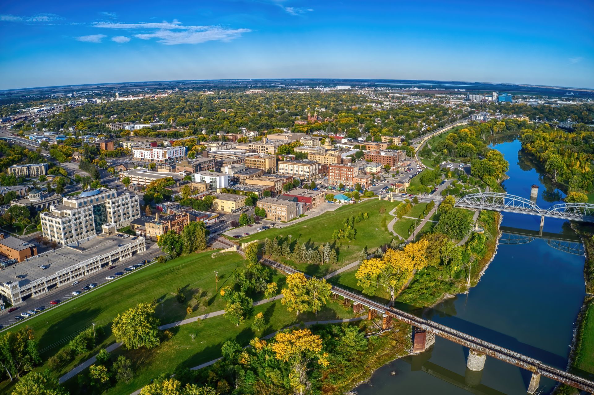 an aerial view of a city with a river and a bridge .