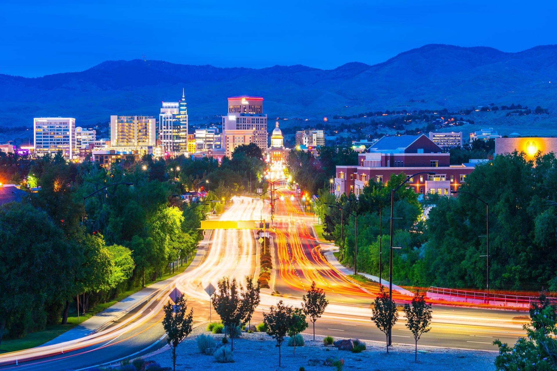 an aerial view of a city at night with mountains in the background .