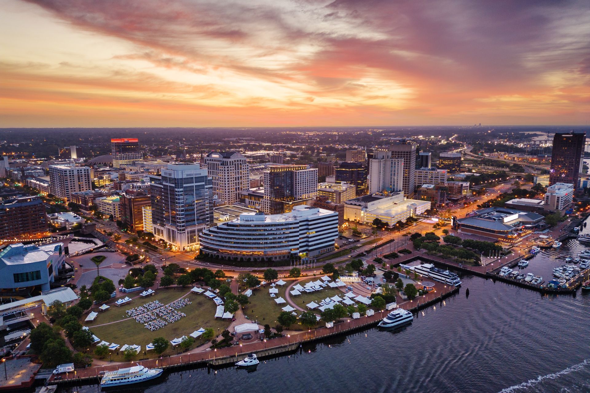 an aerial view of a city at sunset with a river in the foreground .