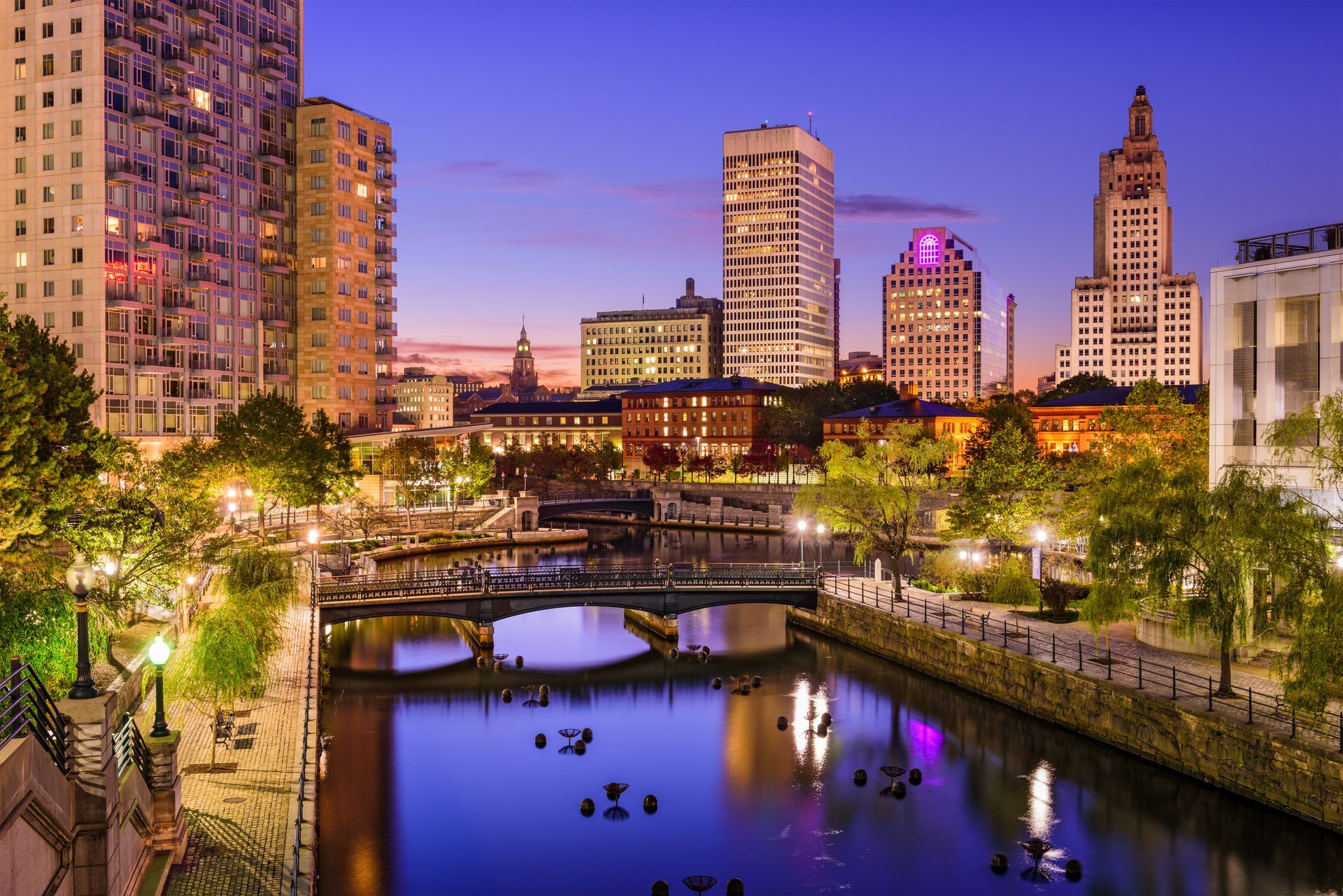 a city skyline at night with a river in the foreground .