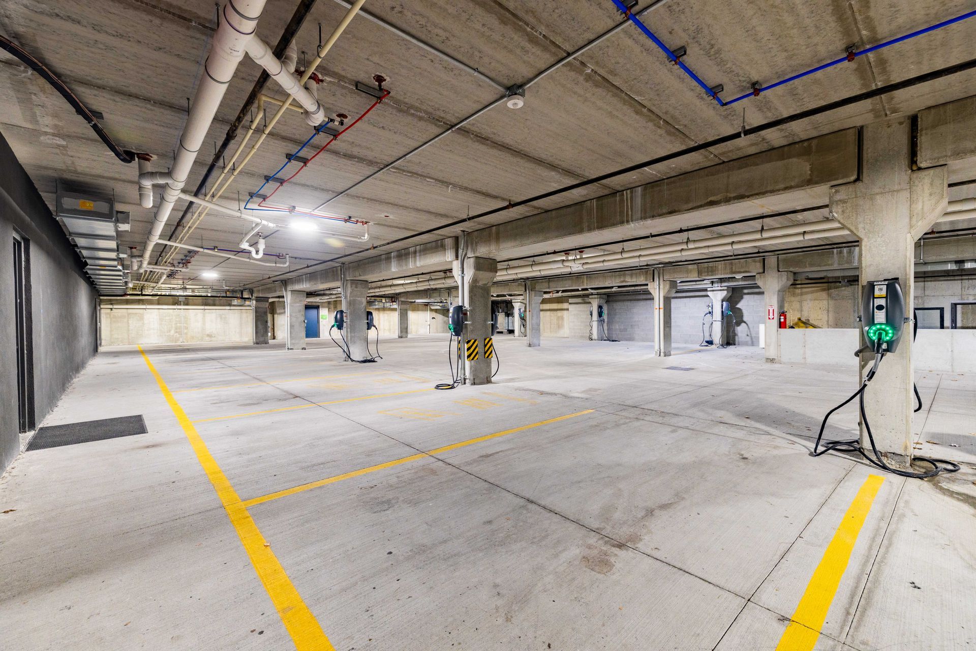 Empty underground parking garage with painted lanes and ceiling lights