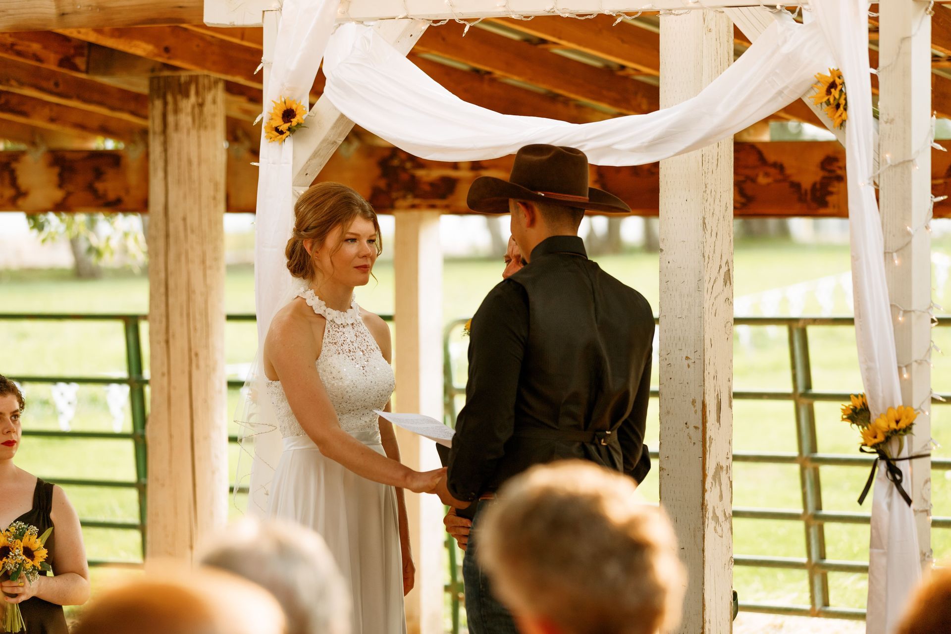 A bride and groom are holding hands during their wedding ceremony.