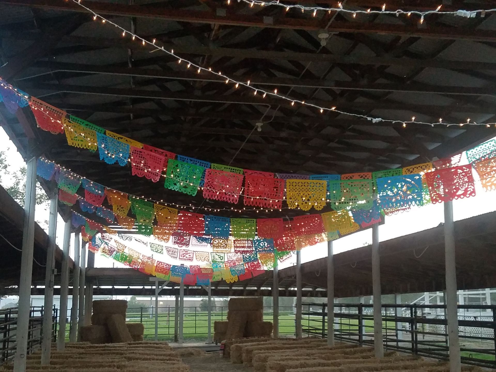 A barn with colorful paper flags hanging from the ceiling