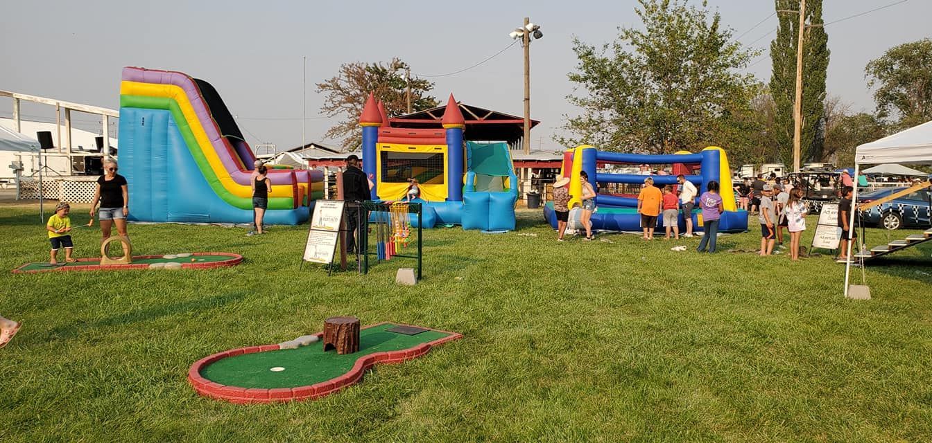 A group of people are playing mini golf in a park.