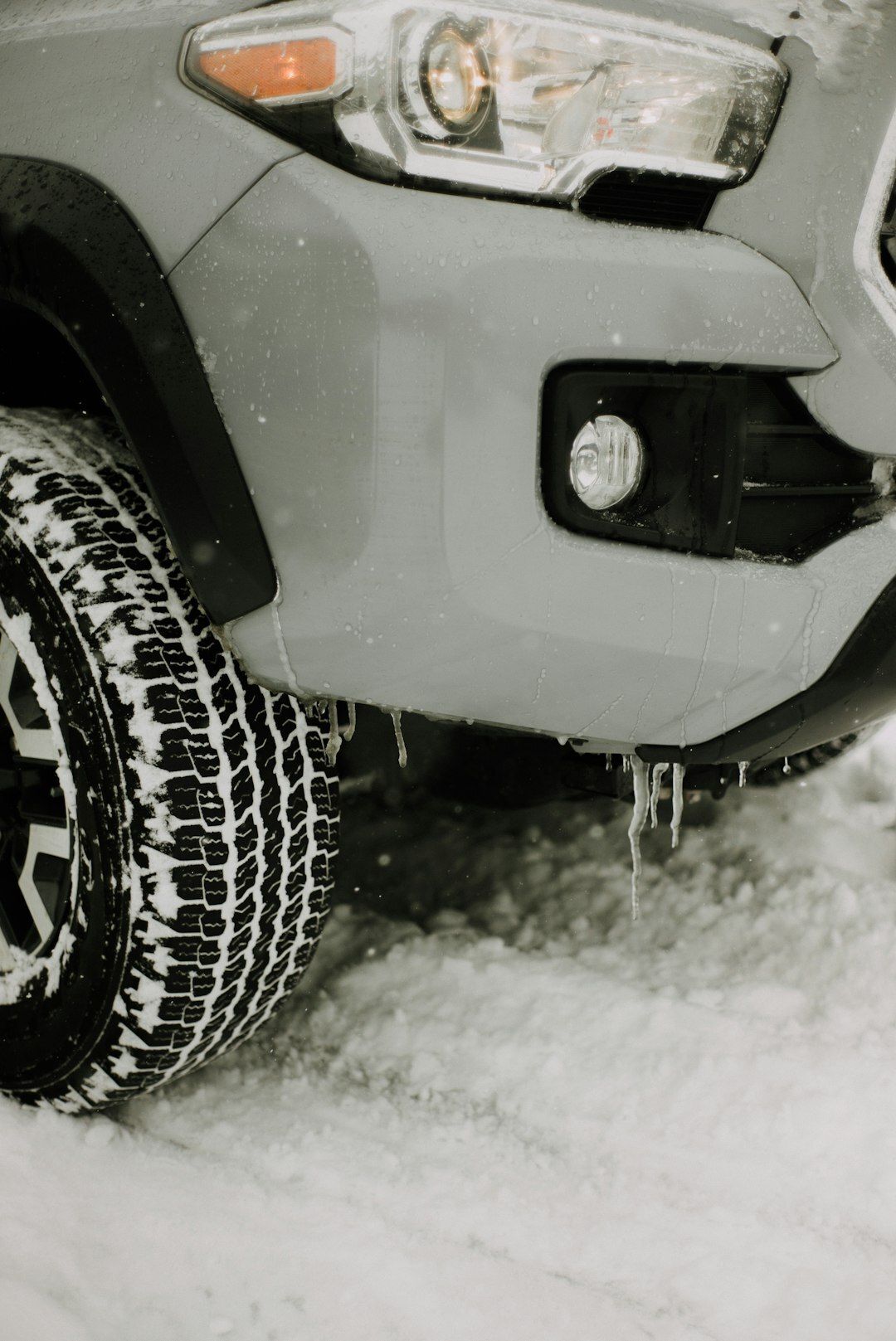 A close up of a car 's tire in the snow.