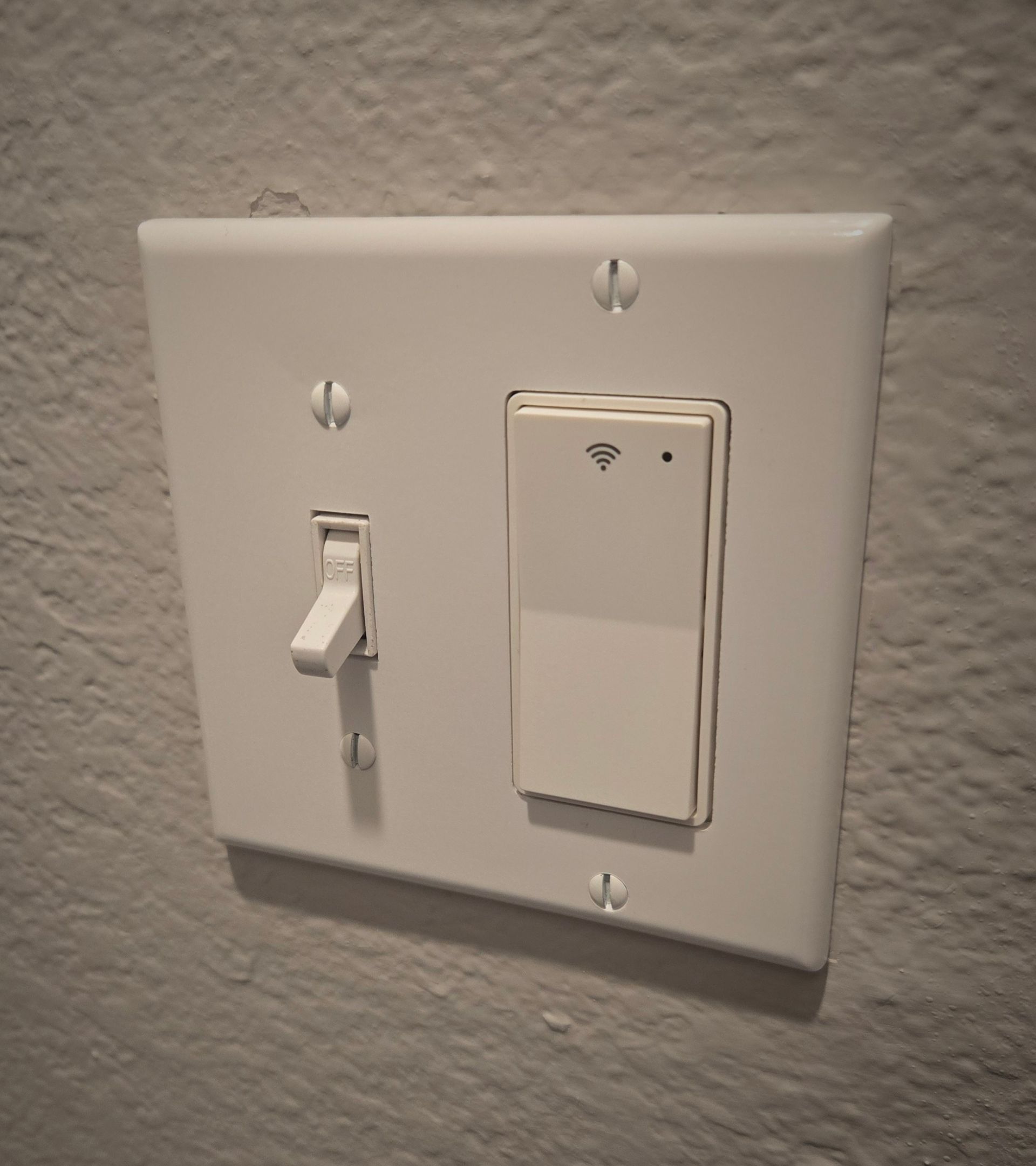 White wall switch plate with a toggle switch and wireless remote control dimmer.