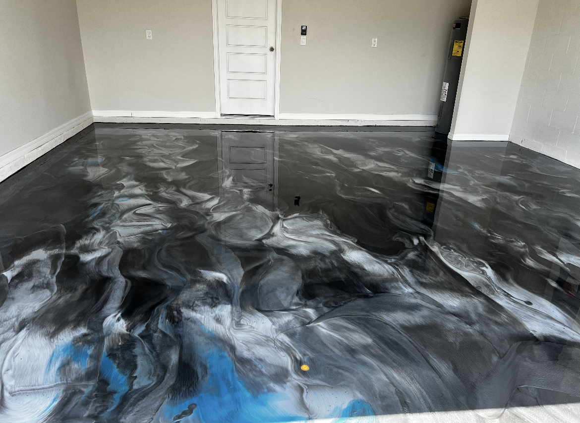 Empty room with glossy black-and-white marbled floor and a white door in the back wall