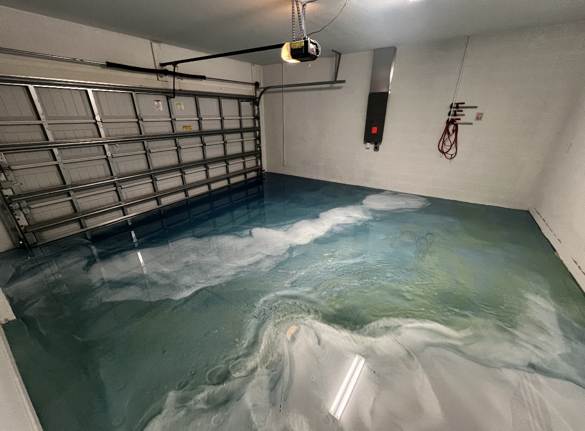 Flooded garage with blue water covering the floor and a closed garage door.