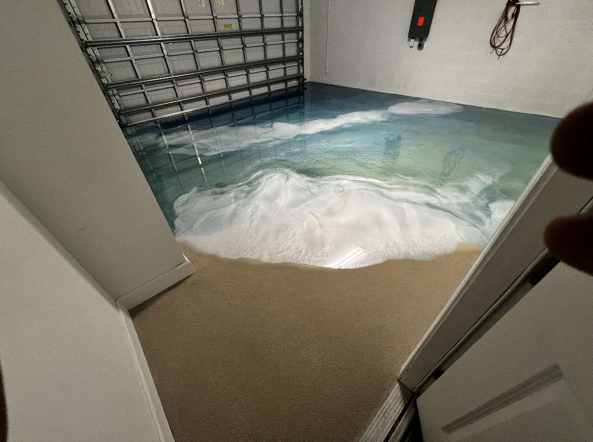 Flooded room with water spilling across the floor toward a doorway and metal gate.