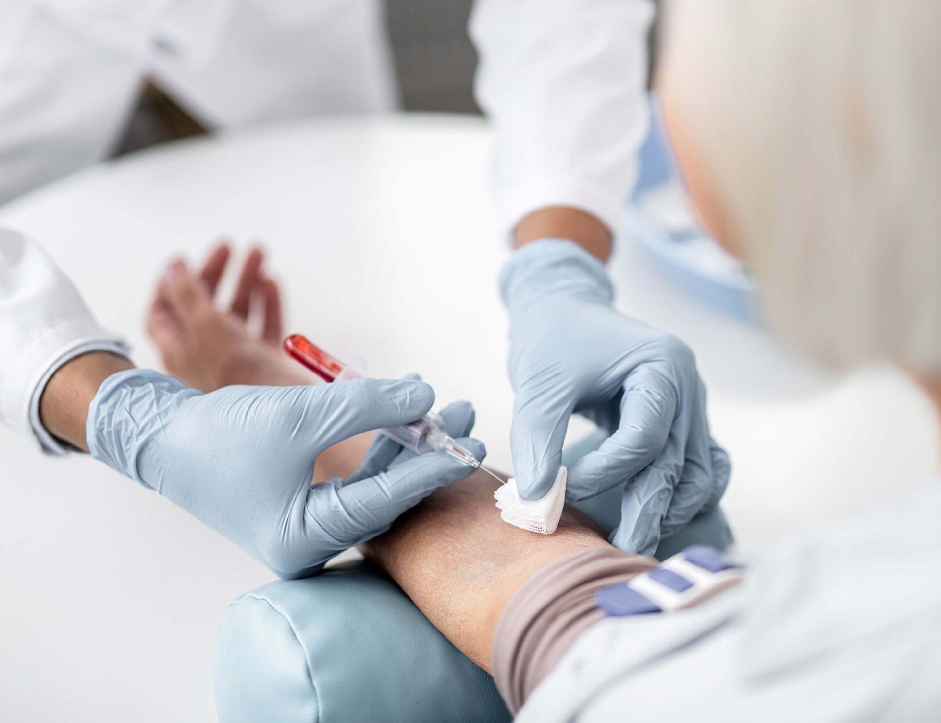 Gloved hands filling a DNA test tube with blood from a syringe, medical form in background.