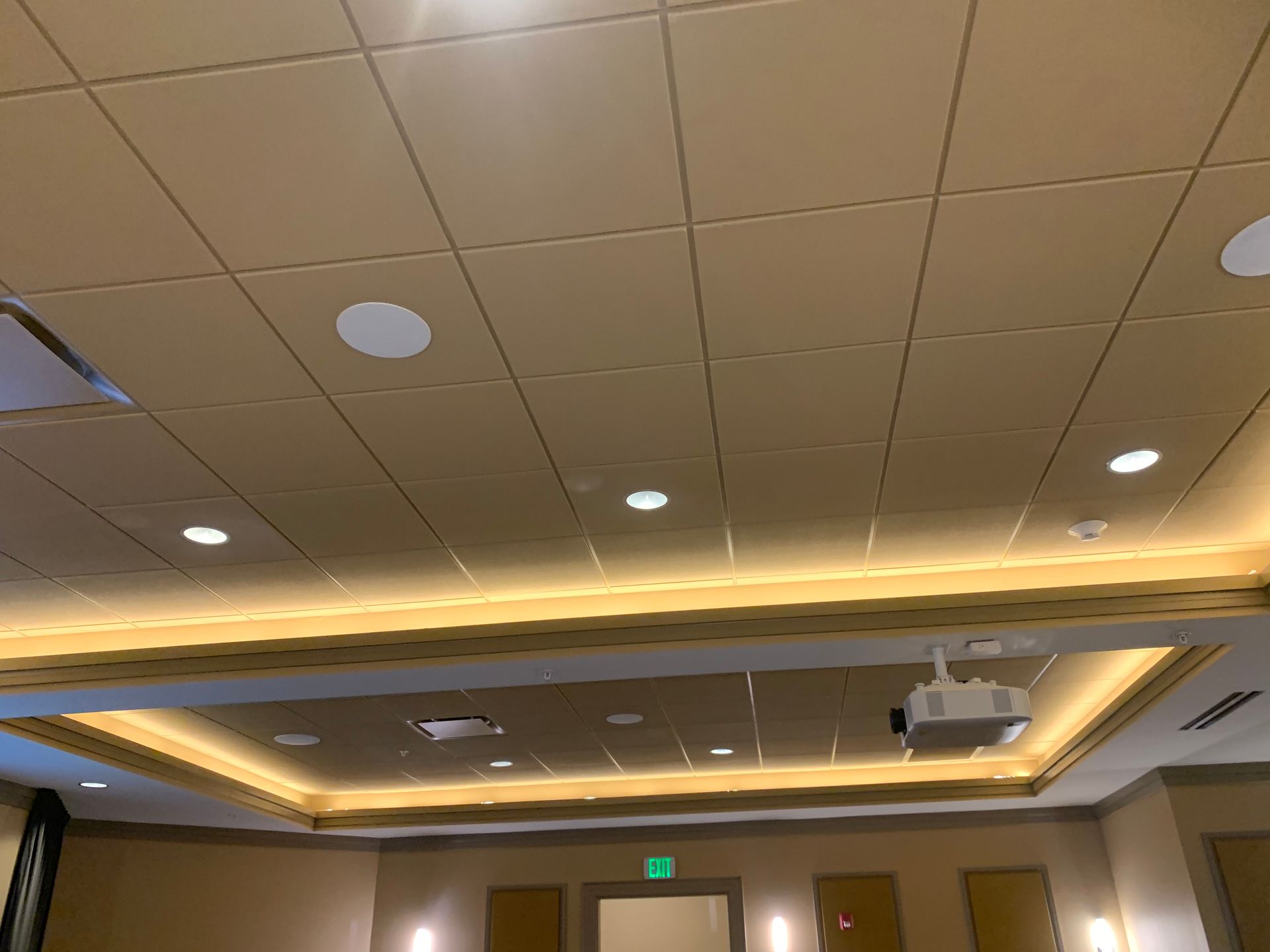 Empty conference room ceiling with recessed lights and a projector