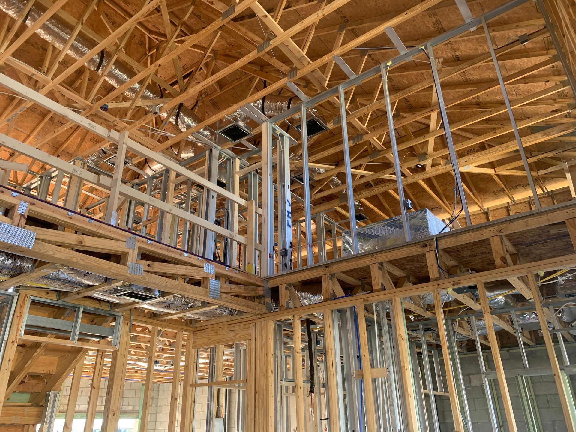 Interior of a house under construction with exposed wooden framing and roof trusses