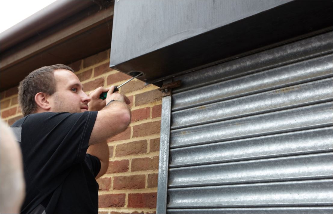 A man working on a security shutter door
