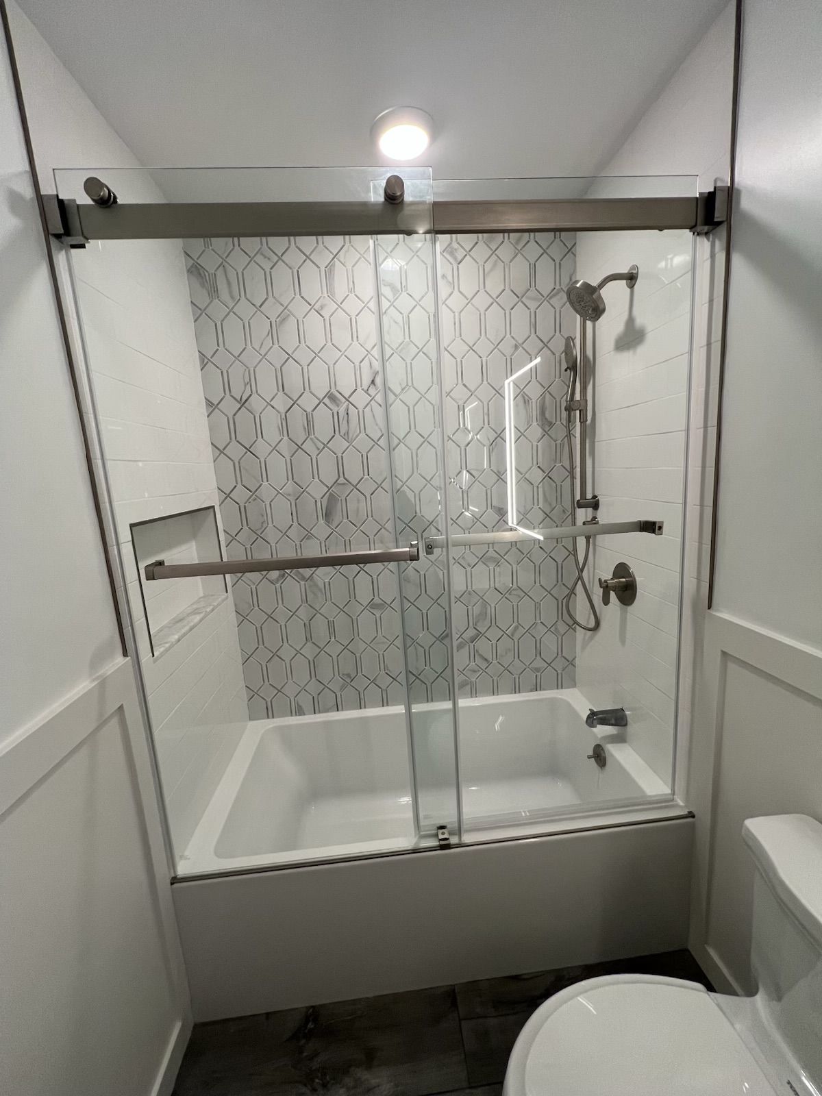 A bathroom with a bathtub , toilet and shower.