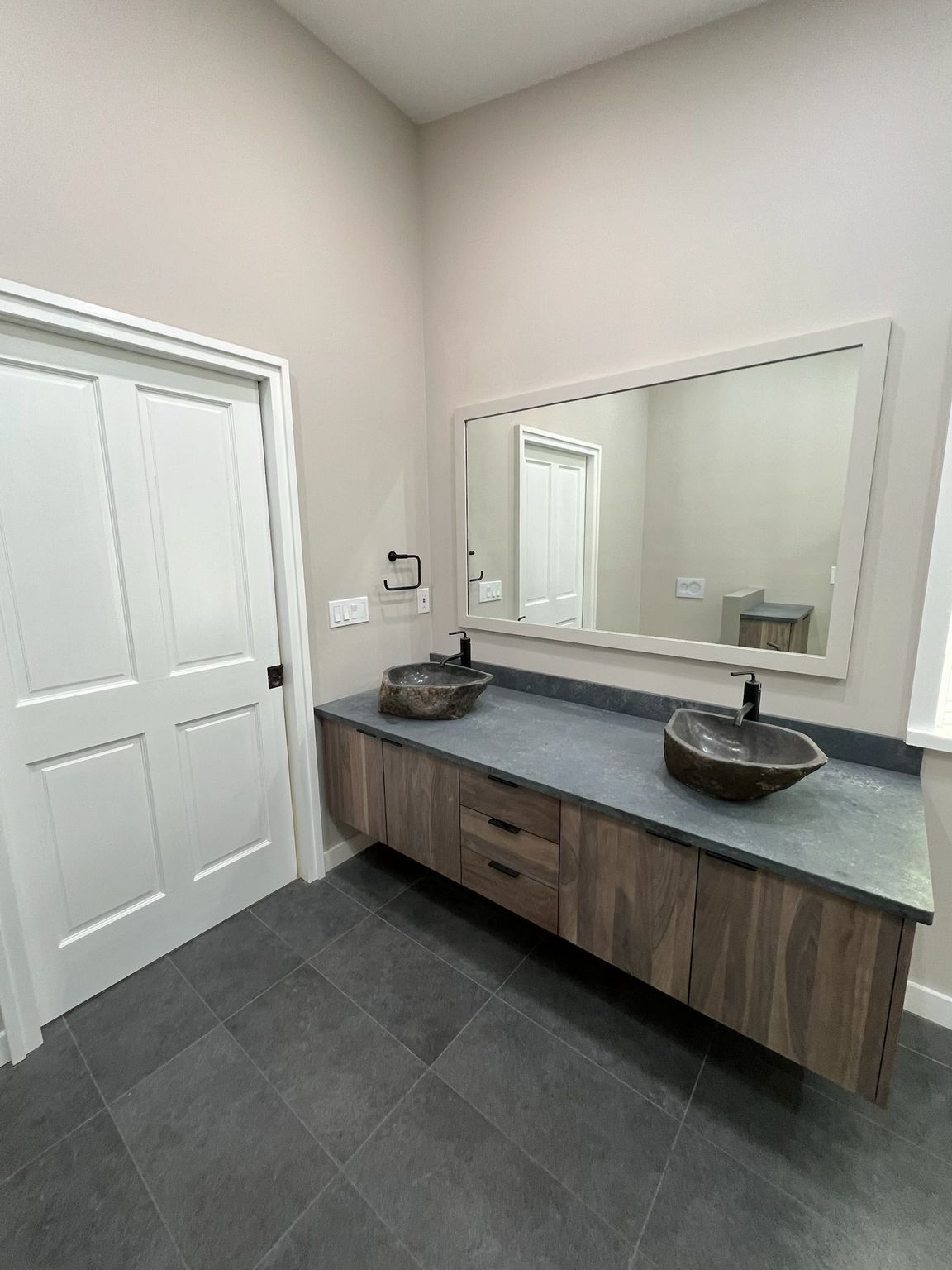 A bathroom with two sinks and a large mirror.