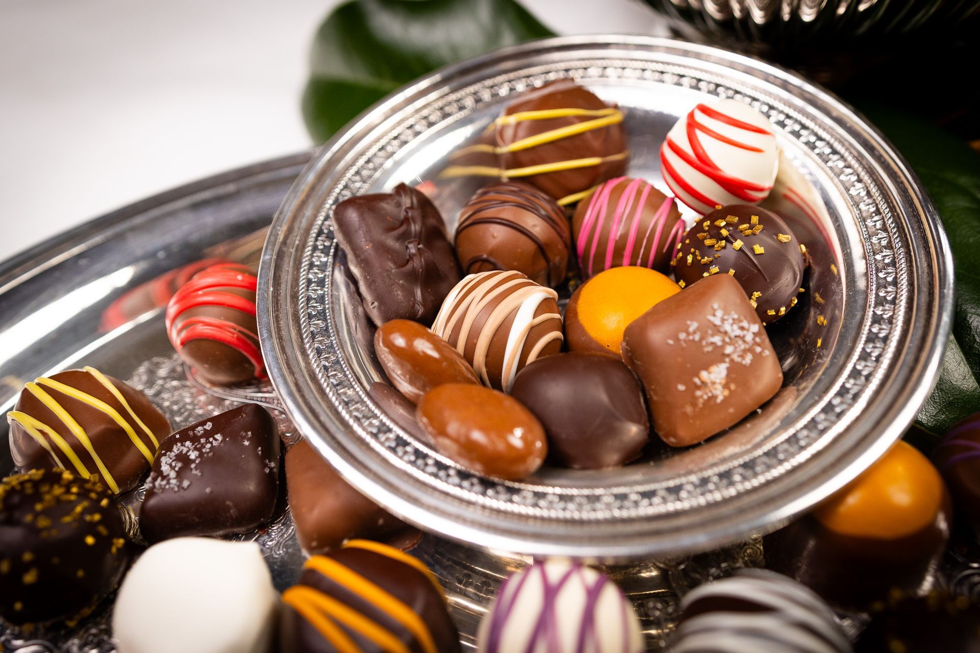 Close-up of a silver platter with assorted colorful chocolate truffles.