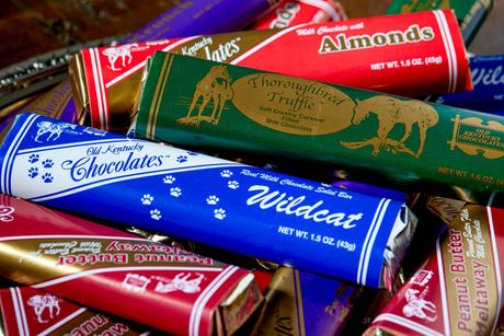 Close-up of assorted chocolate bar wrappers in red, green, blue, gold, and white. 