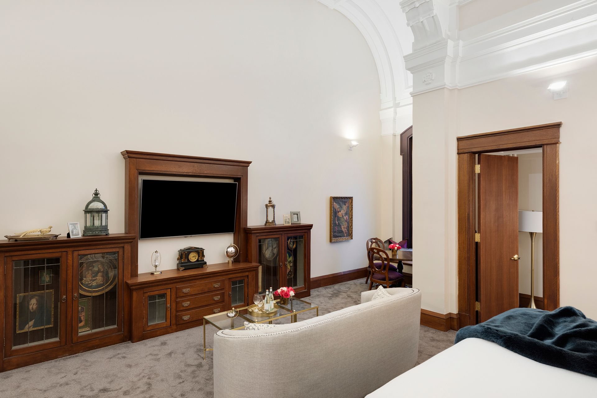 Living room with wood TV cabinet, white sofa, and open doorway to a hallway