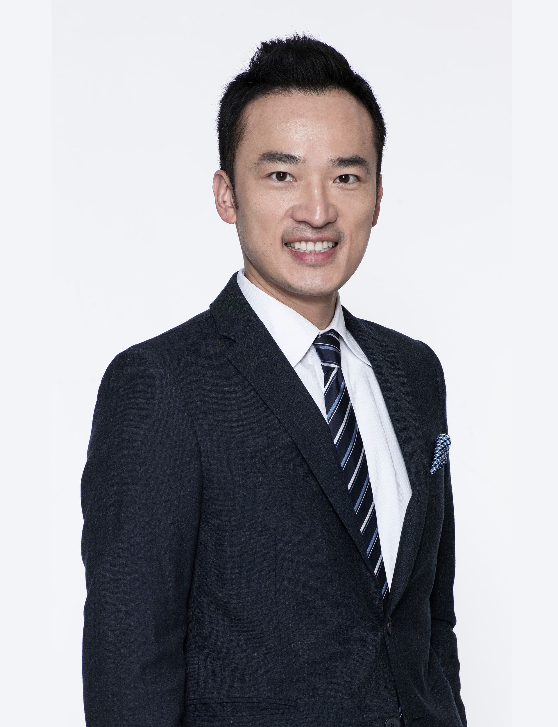 A man in a suit and tie is smiling for the camera.