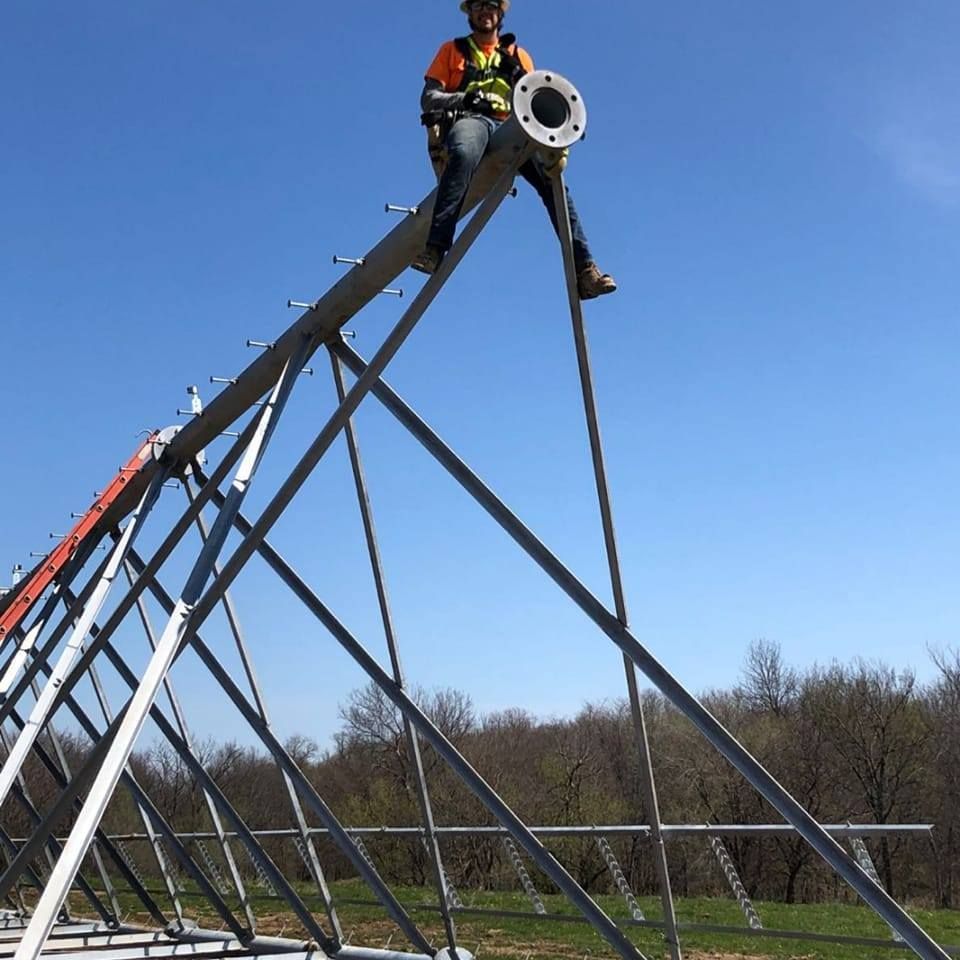 A man is sitting on top of a metal structure