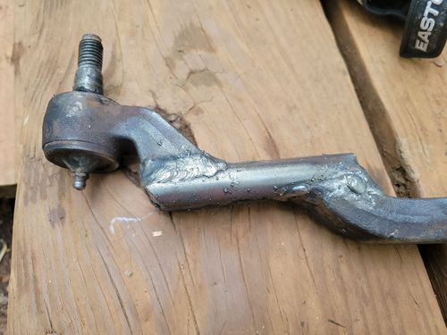 A piece of metal is sitting on top of a wooden table.