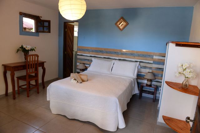 Bedroom with double bed, desk, blue wall, and wooden furniture.