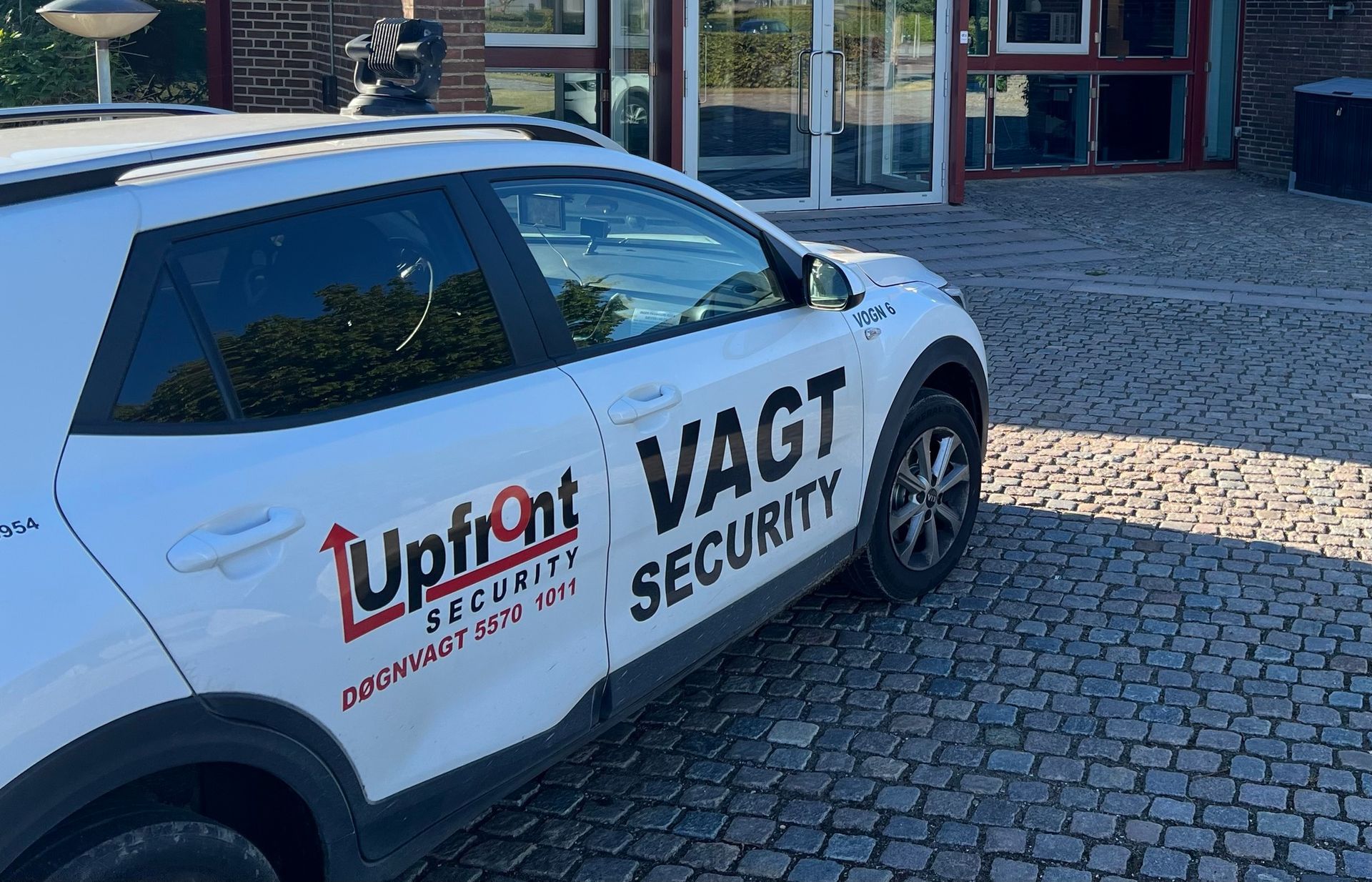 Billede af en bil fra Upfront Security parkeret foran en bygning