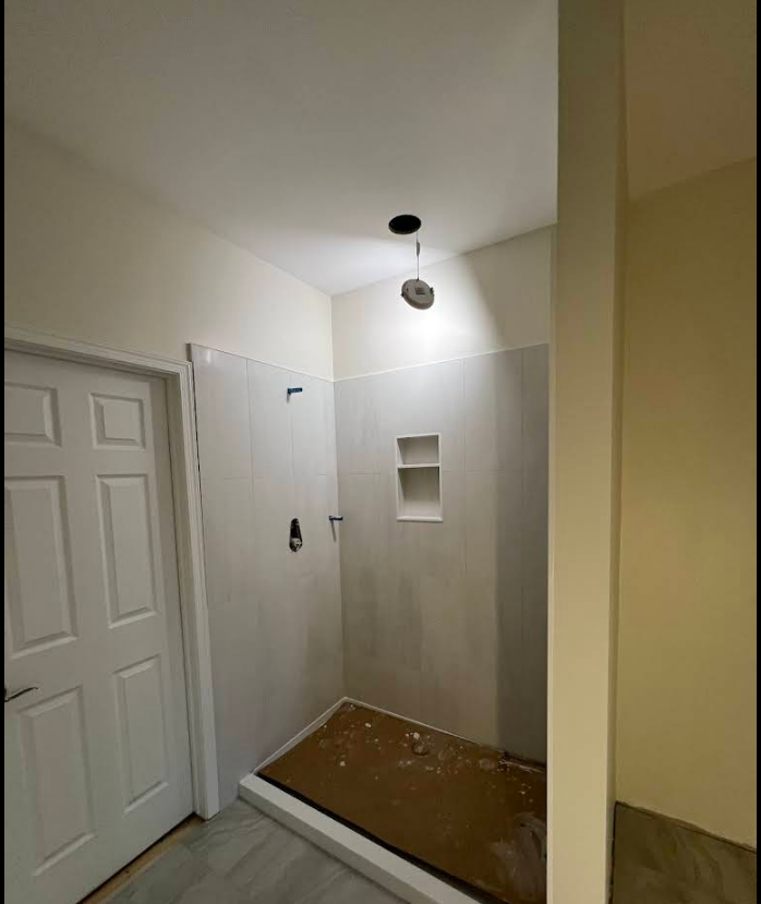 A bathroom with a walk in shower and a door.