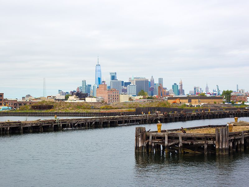 New York City skyline across the water with a wooden pier in the foreground