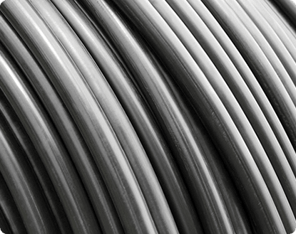 Close-up van opgerolde zwarte en zilverkleurige metalen draden of kabels.