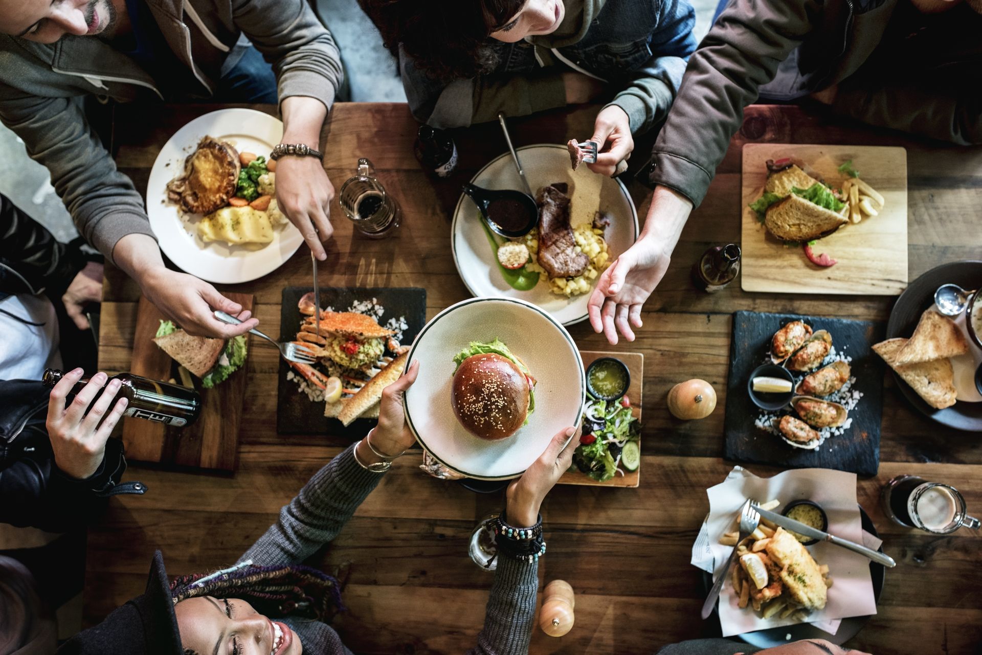 A group of people are sitting around a table eating food.