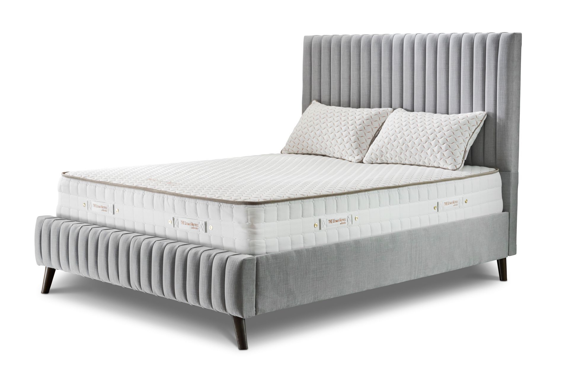 Gray upholstered bed with a high, vertical-lined headboard; two pillows rest on the mattress.