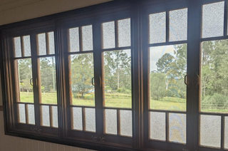 Large Dark-framed Window With Textured Glass Panes Overlooking Trees — Glass Installations & Repairs in Gympie, QLD