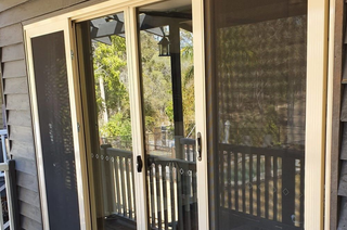 Sliding Glass Doors Opening Onto a Screened Porch With Wooden Railing — Glass Installations & Repairs in Gympie, QLD
