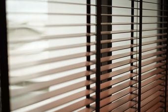 Closed Window Blinds with Sunlight Filtering Through, Casting Striped Shadows — Glass Installations & Repairs in Gympie, QLD