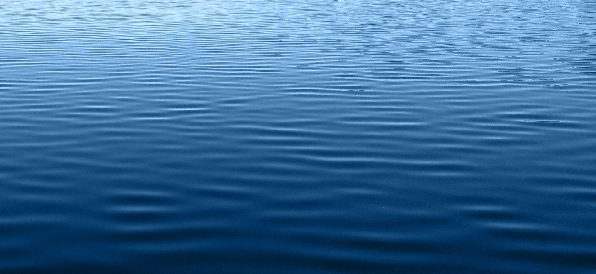 A close up of a blue water surface with waves