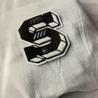 A black and white photo of a patch on a white shirt.
