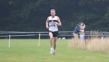 A man is running on a grassy field.