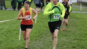 A group of people are running on a grassy field.