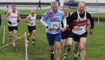 A group of men are running in a cross country race.