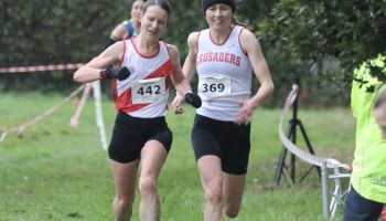 Two women are running in a cross country race.