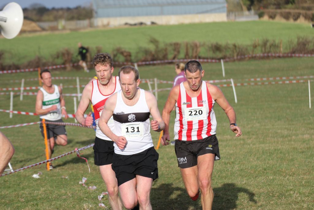 A group of men are running on a grassy field.
