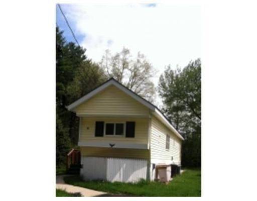 A small yellow house with a white garage door